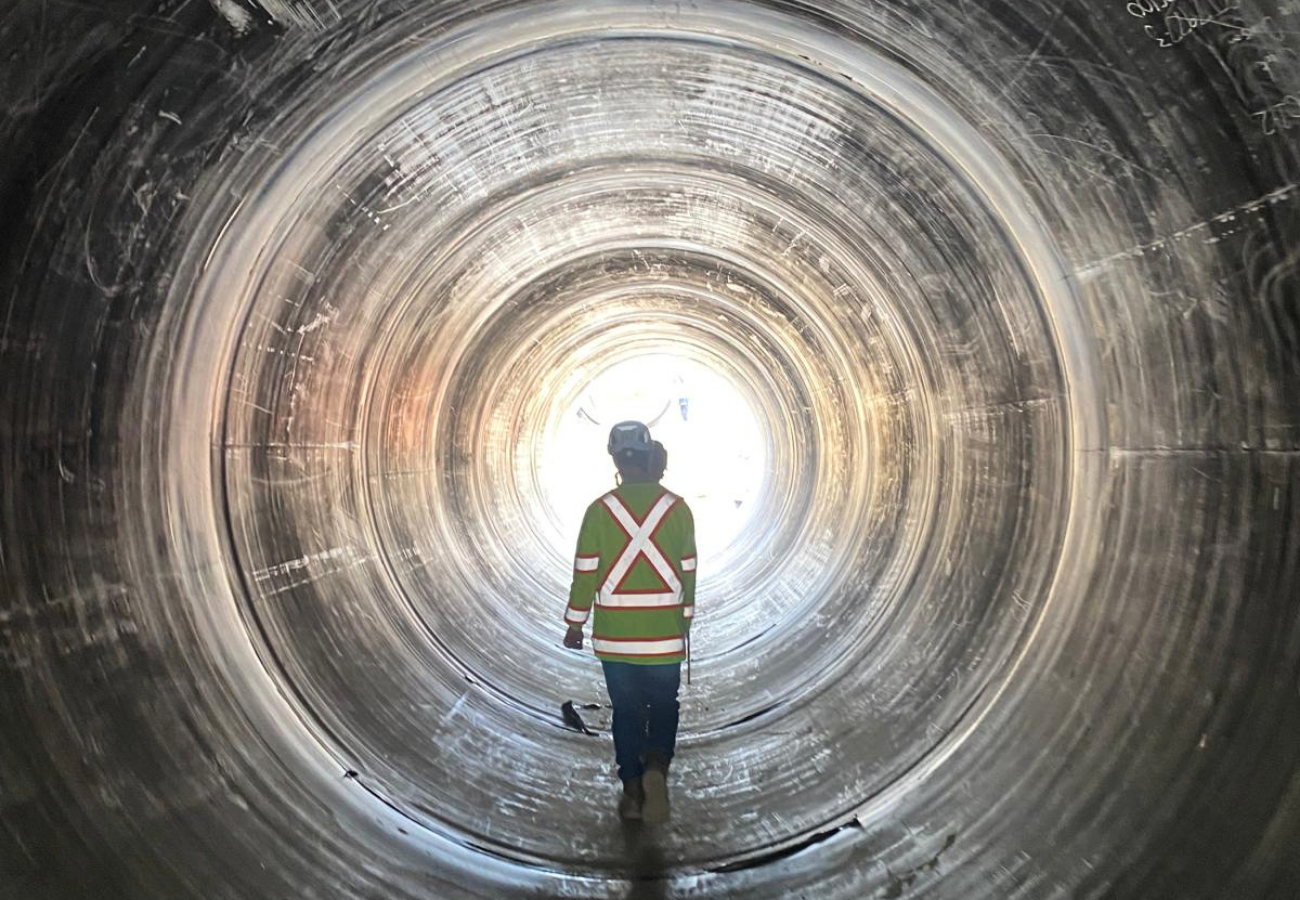 Harania Creek - Infrapipe Team member walking inside a large Infrapipe NZ pipeline supplied for the Harania Creek wastewater diversion project.